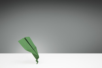 Green Paper airplane with a bent nose