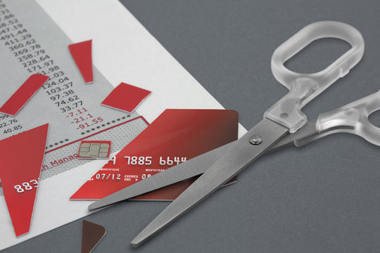 Cut up Credit Card and pair Scissors on top of a Bank Statement