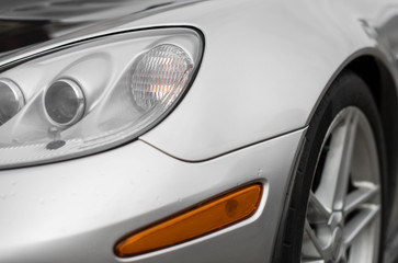 Obraz na płótnie Canvas Close-up view of silver sports car headlight.