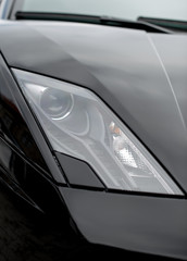 Close-up view of black sports car headlight.