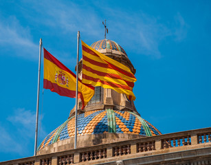 Naklejka premium The national flag of Catalonia and Spain on a bright dome of the old building