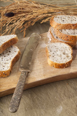 Bread, a set of variation of breads on a wood chopping block with a brass knife