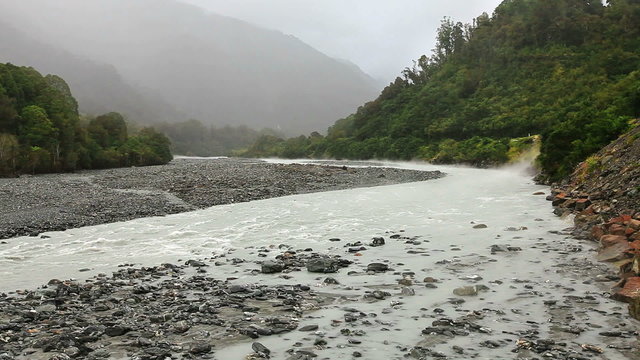 Misty stream running from glacier under rainfall. South island, New Zealand.