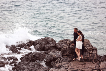 Bride and groom embracing at the beach