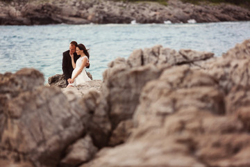 Bride and groom embracing at the beach