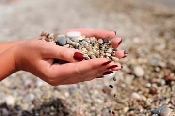 Hands dropping small stones