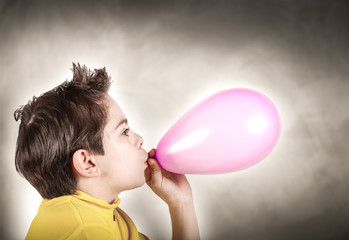 ragazzino che gonfia palloncino