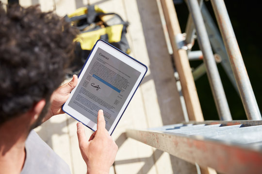 Construction Worker Signing Contract On Digital Tablet