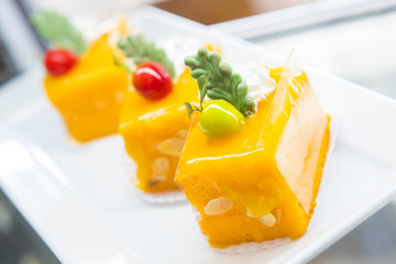 Slice of colourful layered birthday cake decorated with sprinkle
