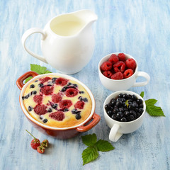 Homemade cake with raspberries and blueberries on blue wooden background