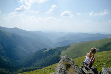 Young blond woman meditating in the beautiful mountain landscape