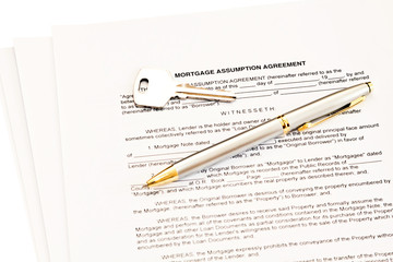 Mortgage assumption agreement with a pen for signature and a key