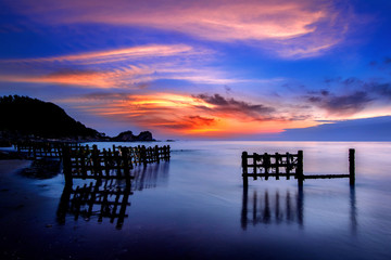 Fototapeta premium seascape with row of wood at sunset