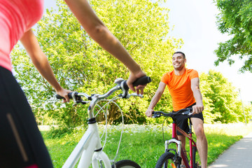 close up of happy couple riding bicycle outdoors