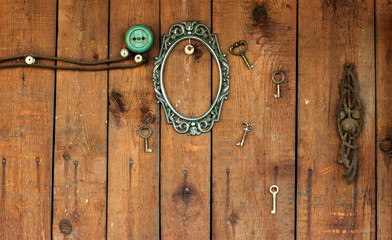 vintage frame and key on wooden wall with power outlet