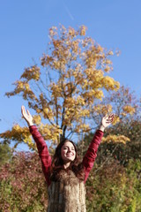 Happy woman in fall with raised arms