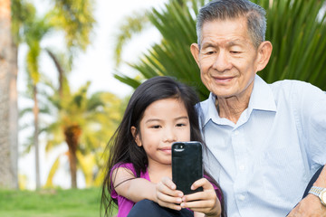 Grandfather and grandchild making selfie with smart phone in the