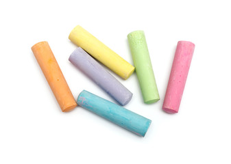 chalks in a variety of colors arranged on a white background - obrazy, fototapety, plakaty