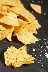 Nachos and salt on a dark background, selective focus