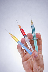 Three colorful syringes