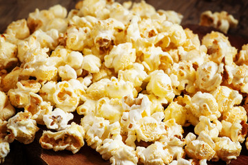 Sweet caramel popcorn in a wooden bowl, selective focus