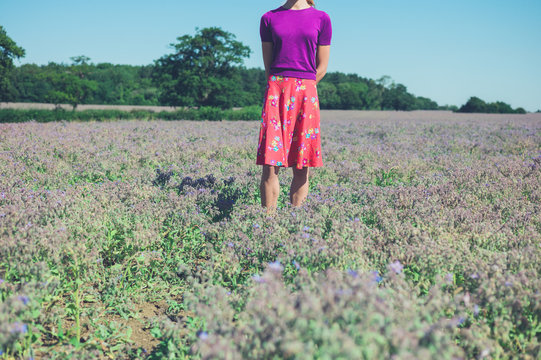 Woman standing in field of purple flowers