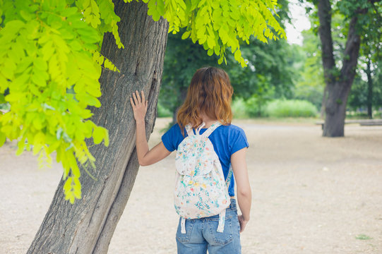 Young woman standing uinder a tree in the park