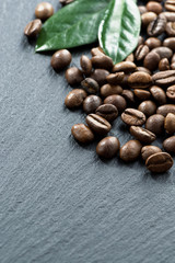 coffee beans and leaves on dark background, space for your text