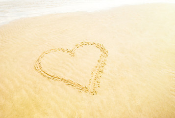 Fototapeta na wymiar Heart in the sand on the beach, retro look