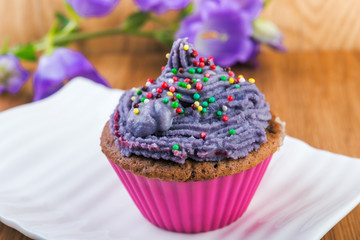 Cupcakes on white plate decorated with berries and wild flowers
