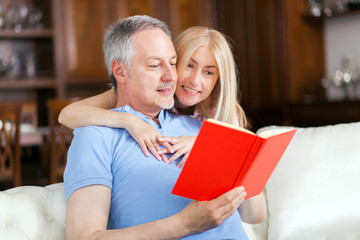 Happy mature couple reading a book