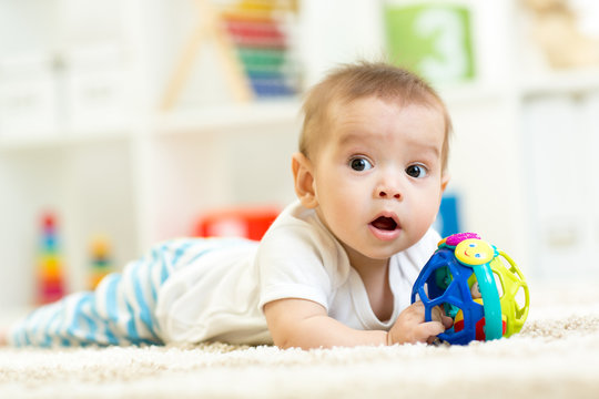 baby playing on a carpet at home