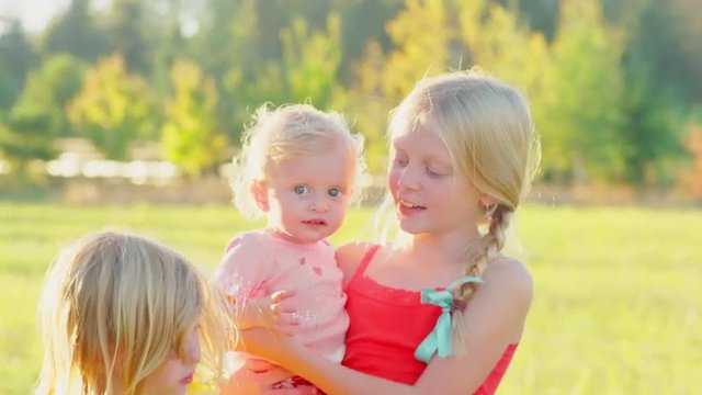Cute blonde girls outside with a toddler