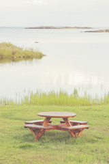 Fototapeta premium Bench at seashore with lush grass and view over the seascape