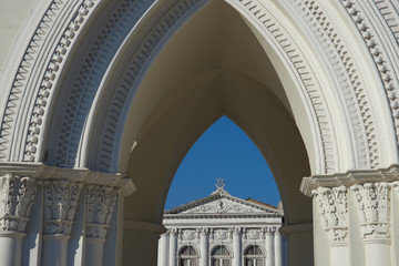 White classical style theatre in Plaza Arturo Prat in the old quarter of Iquique on the Pacific coast of northern Chile. Viewed through an arch of the clock tower.