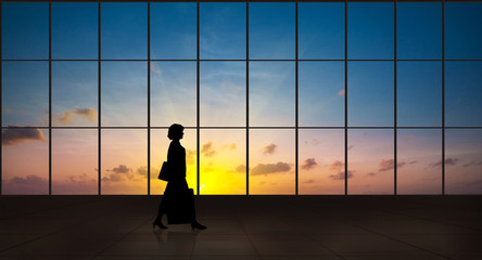 Business woman walking alone silhouette in the airport