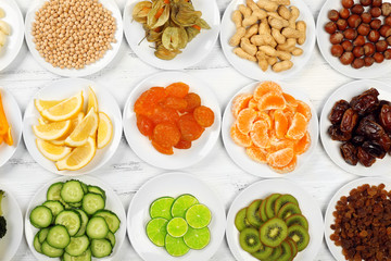 Different products on saucers on wooden table, top view