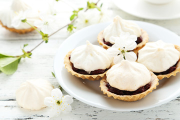 French meringue cookies in tartlet on white wooden background