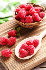 Red raspberries on cutting board on grey wooden background