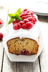 Raspberry cake on plate on grey wooden background