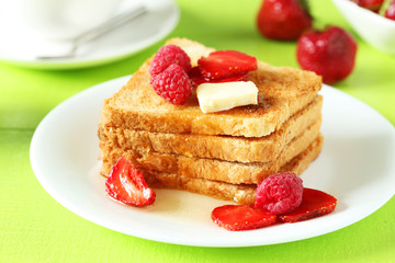 Fresh toast with raspberry and strawberry on green wooden backgr