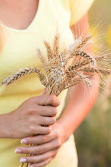 Girl with with ripe ears of barley in hand