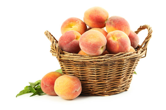 Fresh peach fruit in basket isolated on a white