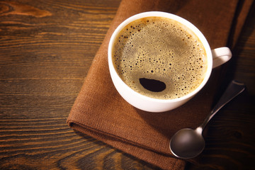 Cup of coffee on napkin on table close up