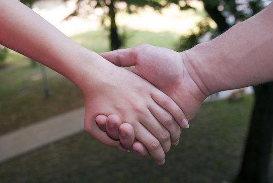 An young couple holding hands. Small depth of field. 