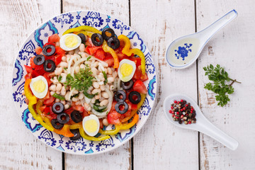 Salad with white beans and fresh vegetables,olives and egg, Turkish cuisine.selective focus