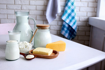 Dairy products on wooden table, on brick wall background