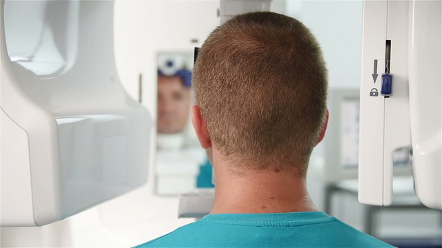patient looks in the mirror during the computer scan of the head
