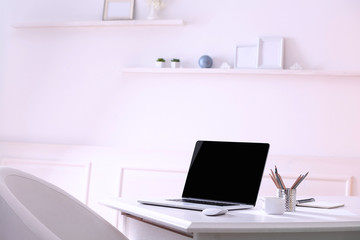 Workplace with laptop in room