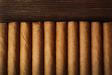 Cigars on wooden table, top view